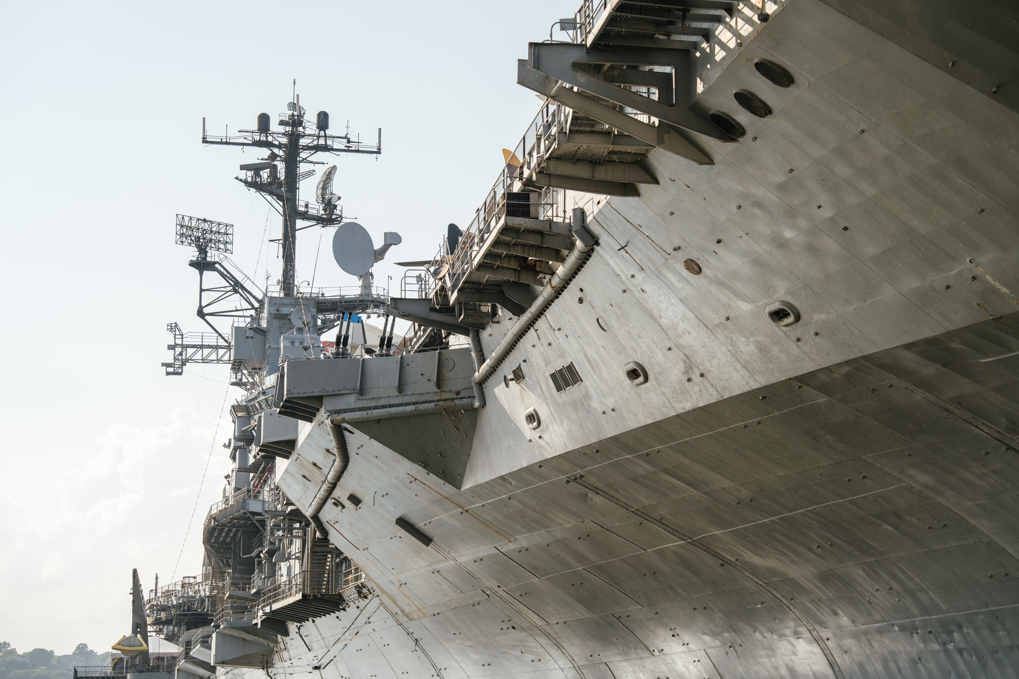 Close-up view of a U.S. Navy military vessel showcasing radar systems, antennas, and armored hull structure